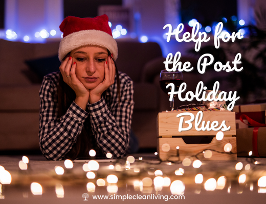 Help for the post holiday blues blog post- a picture of a woman laying on the floor with her head in her hands wearing a Santa hat and looking sad