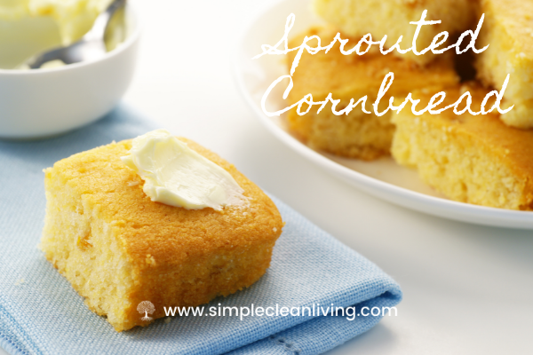 A plate piled with sprouted cornbread alongside a napkin with a piece of cornbread topped with butter