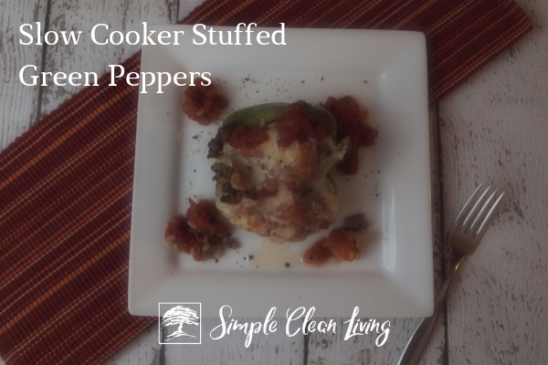 A picture of a stuffed green pepper on a plate with the blog post title "Slow Cooker Stuffed Green Peppers"