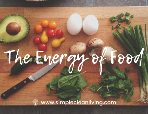 The Energy of Food- A cutting board with a knife, greens, herbs and vegetables