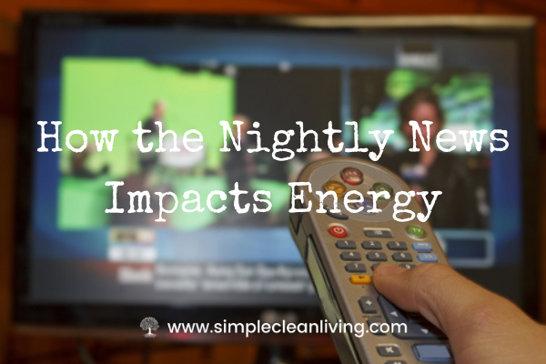 How the nightly news impacts energy- A hand holding a remote control in front of a television with a news broadcast on