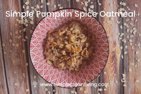 Bowl filled with pumpkin spice oatmeal topped with chopped walnuts