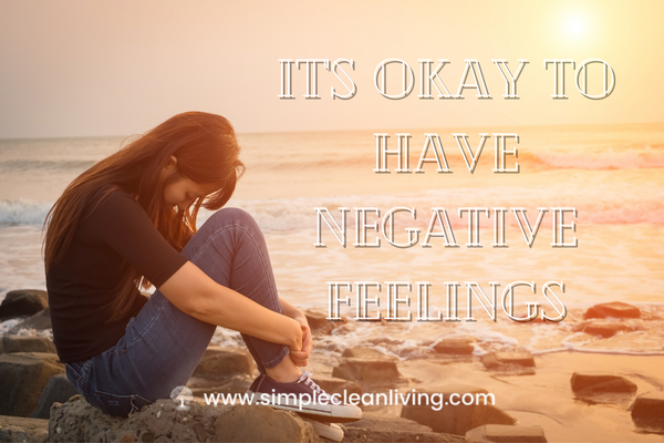 It's Okay to Have Negative Feelings- Picture of woman sitting on the beach looking sad