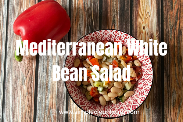 Mediterranean White Bean Salad Blog Post with a picture of a bowl of Mediterranean white bean salad on a table