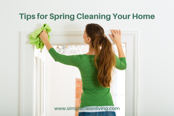 Tips for Spring Cleaning Your Home Blog Post- Picture of a woman wiping down the molding around a window